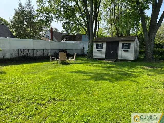 a view of a house with backyard and a tree