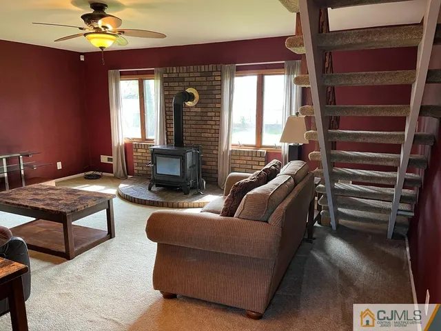 a living room with furniture ceiling fan and a window