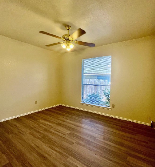 2114 Redwing Way Round Rock, TX 78664 - Photo 7 of 8 Empty room with dark wood-style floors and ceiling fan