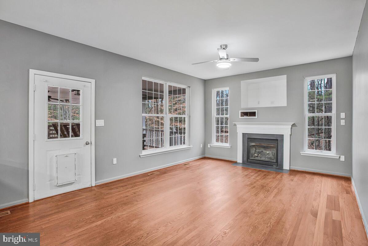 2775 Scientists Cliffs Road Port Republic, MD 20676 - Photo 14 of 54 a view of an empty room with wooden floor fireplace and a window