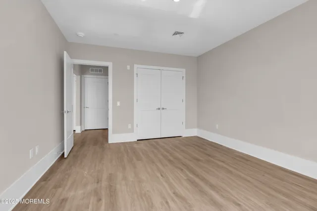 an empty room with wooden floor and view