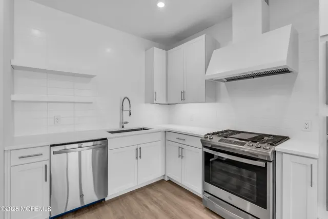 a kitchen with stainless steel appliances granite countertop a stove and a microwave