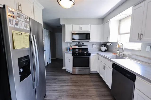a kitchen with stainless steel appliances a refrigerator sink and microwave