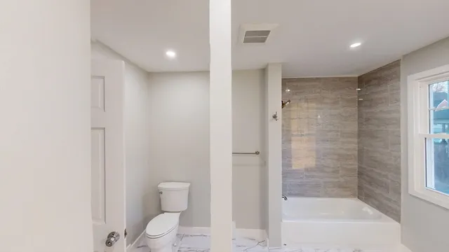 a bathroom with a bathtub sink vanity and mirror