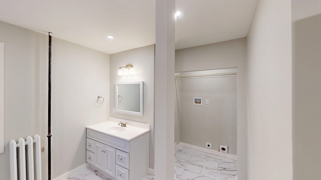168 Oak Street, Unit 1 Gardner, MA 01440 - Photo 13 of 23 a bathroom with a bathtub sink vanity and mirror
