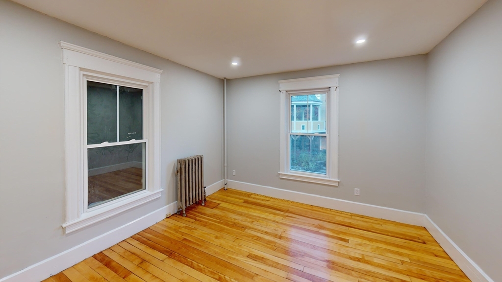 168 Oak Street, Unit 1 Gardner, MA 01440 - Photo 16 of 23 a view of an empty room with wooden floor and a window