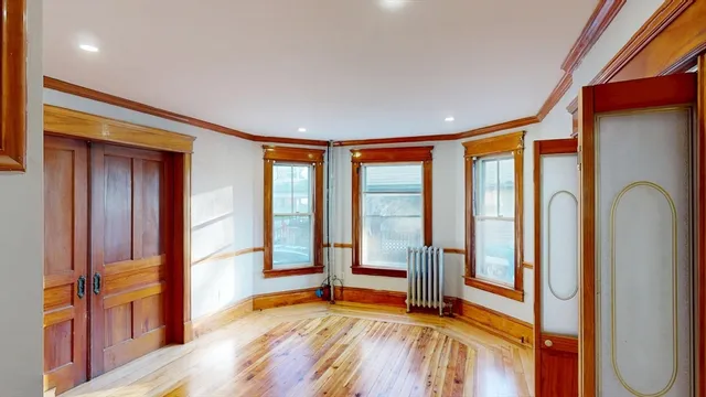 a view of empty room with wooden floor