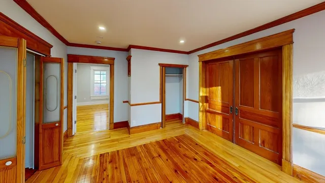 a view of an empty room with wooden floor