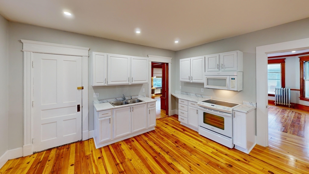 168 Oak Street, Unit 1 Gardner, MA 01440 - Photo 4 of 23 a kitchen with stainless steel appliances granite countertop a stove a sink and a refrigerator