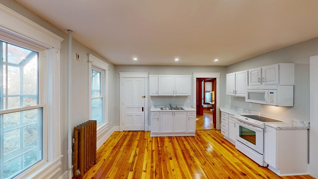 168 Oak Street, Unit 1 Gardner, MA 01440 - Photo 8 of 23 a kitchen with wooden floors and appliances