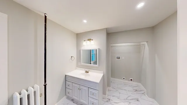 a bathroom with a bathtub sink vanity and mirror
