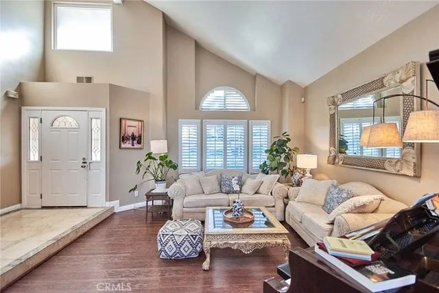 a dining room with wooden floor a chandelier a wooden table and chairs