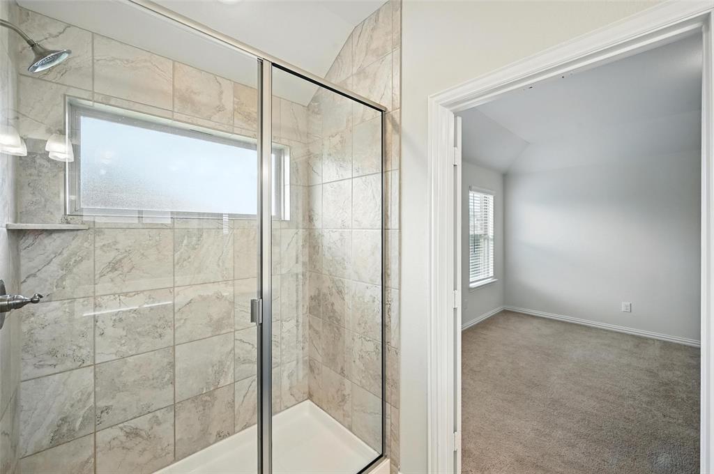 5 Pheasant Run Sanger, TX 76266 - Photo 24 of 27 Bathroom featuring vaulted ceiling, a stall shower, and plenty of natural light