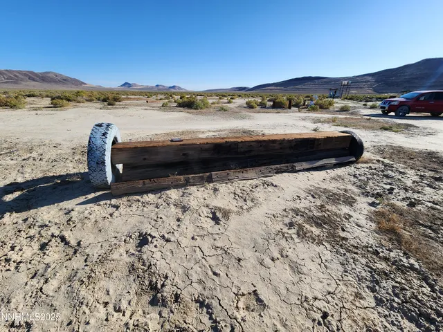a view of a dry yard with wooden fence