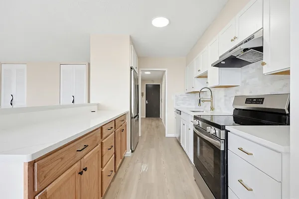 a kitchen with granite countertop white cabinets and white appliances