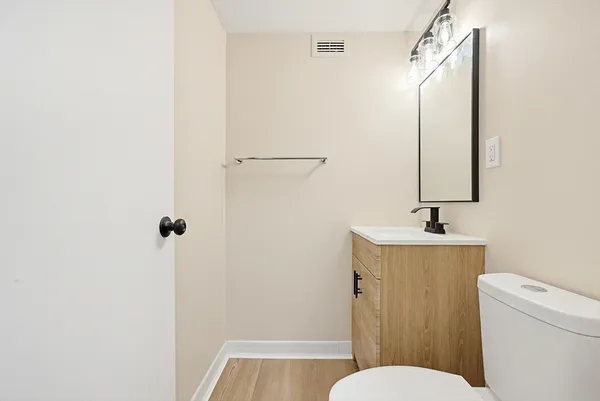 a bathroom with a sink a toilet a mirror and shower