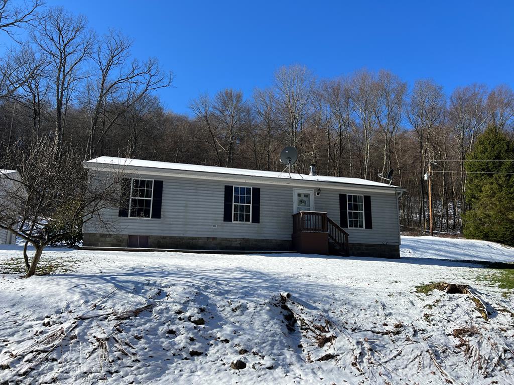 1406 Valley Road Polk, PA 16342 - Photo 1 of 31 a view of a house with a yard covered in snow