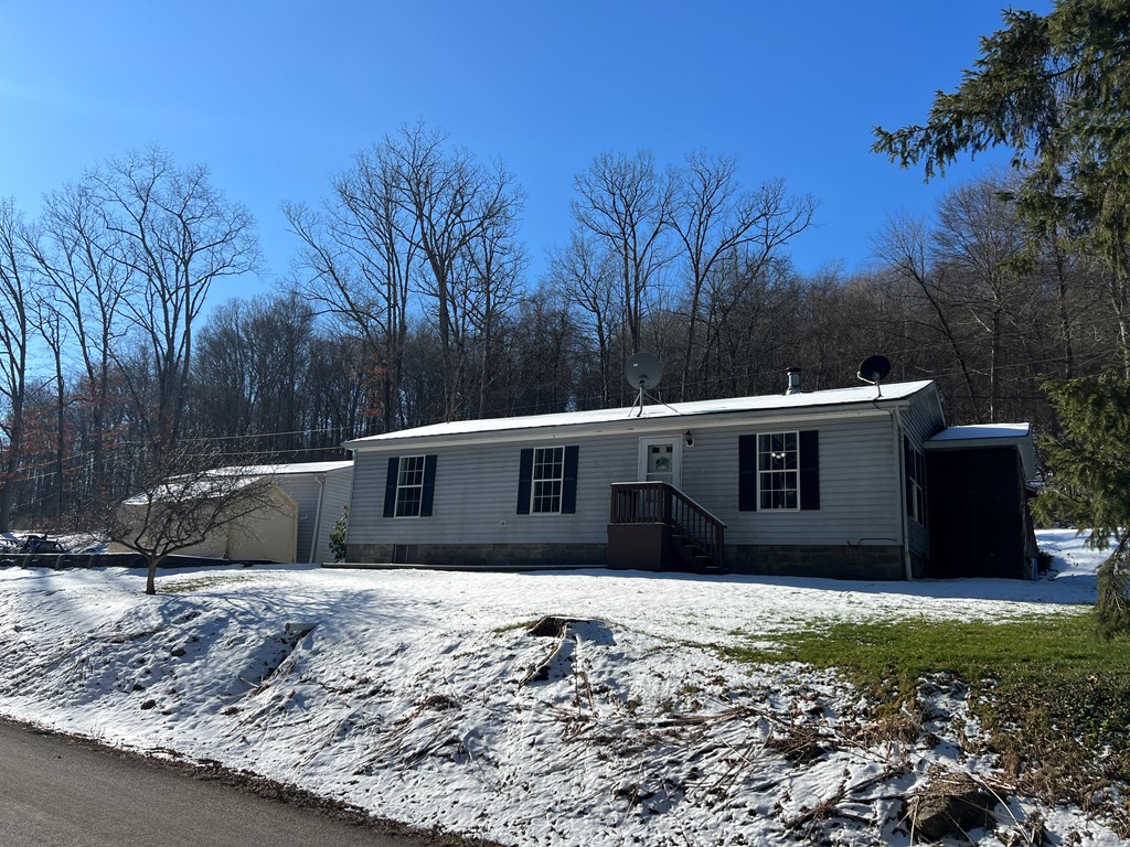 1406 Valley Road Polk, PA 16342 - Photo 2 of 31 a view of a house with a yard covered with snow in the background