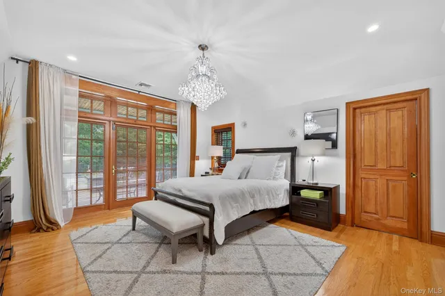 a spacious bedroom with a bed and wooden floor