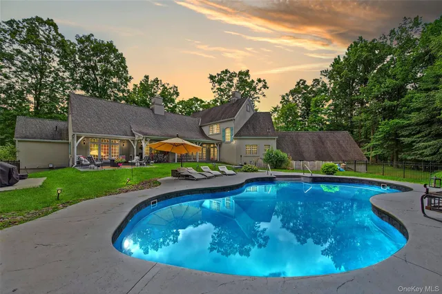a view of a house with backyard swimming pool and sitting area