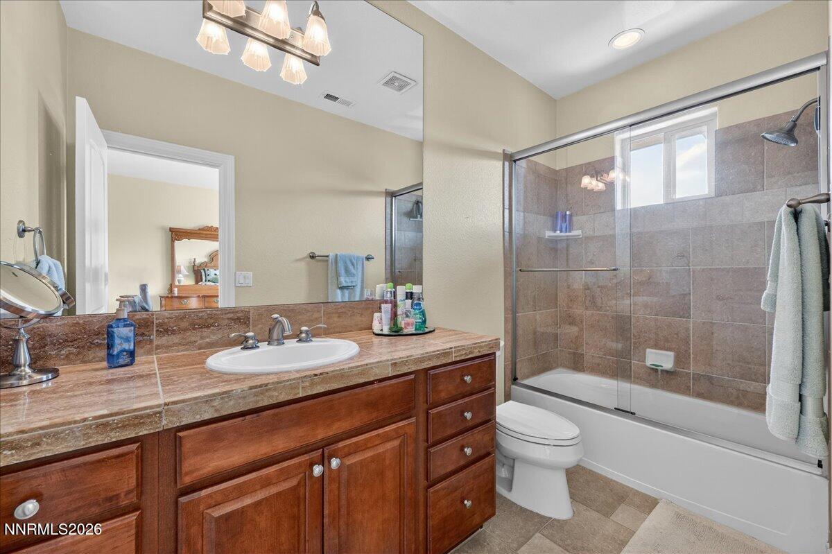 224 South Earlham Court Reno, NV 89511 - Photo 26 of 54 a bathroom with a granite countertop sink toilet a mirror a vanity and shower