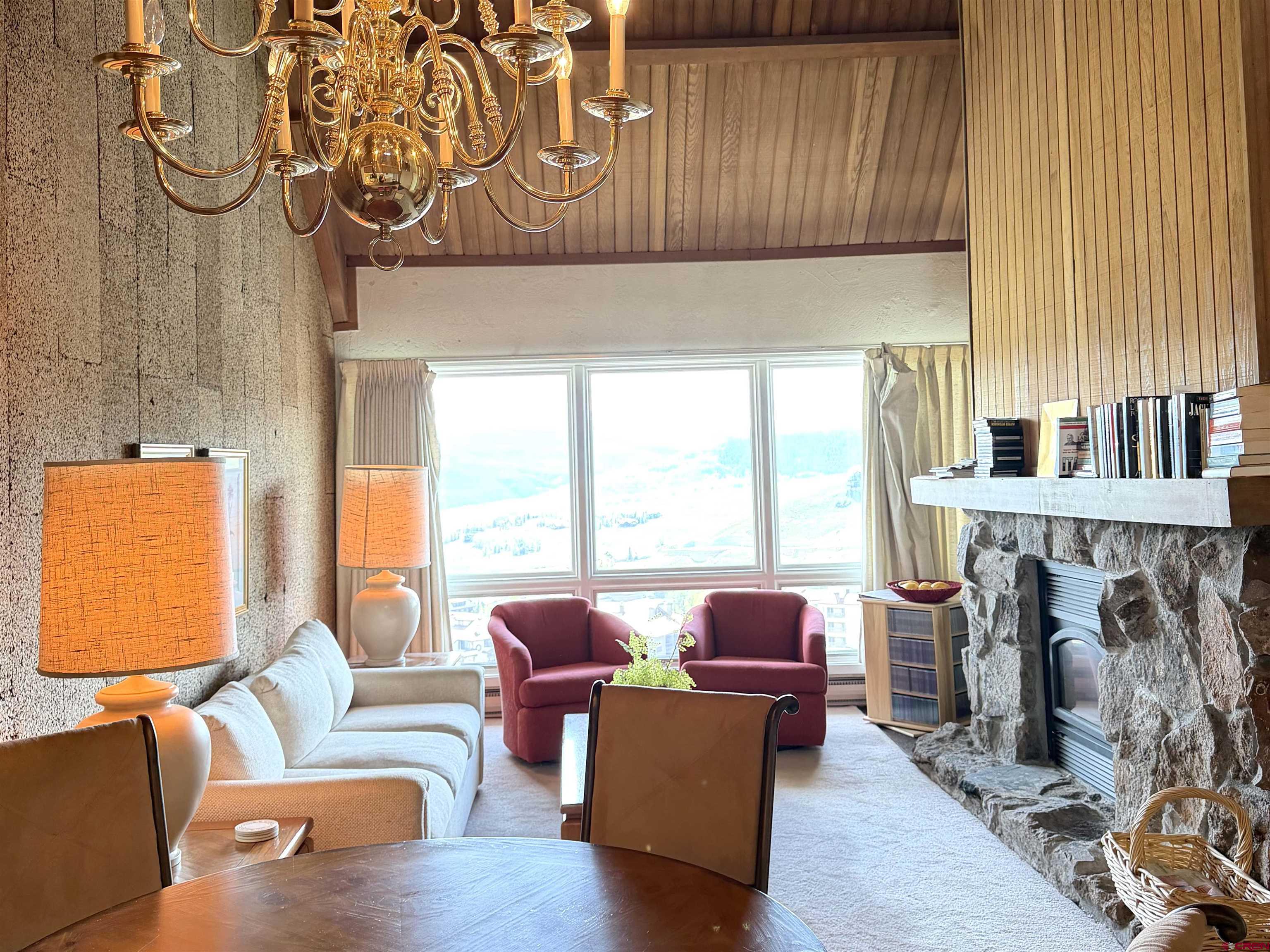51 Whetstone Road, Unit 2306 Crested Butte, CO 81225 - Photo 10 of 44 a living room with fireplace furniture and a floor to ceiling window