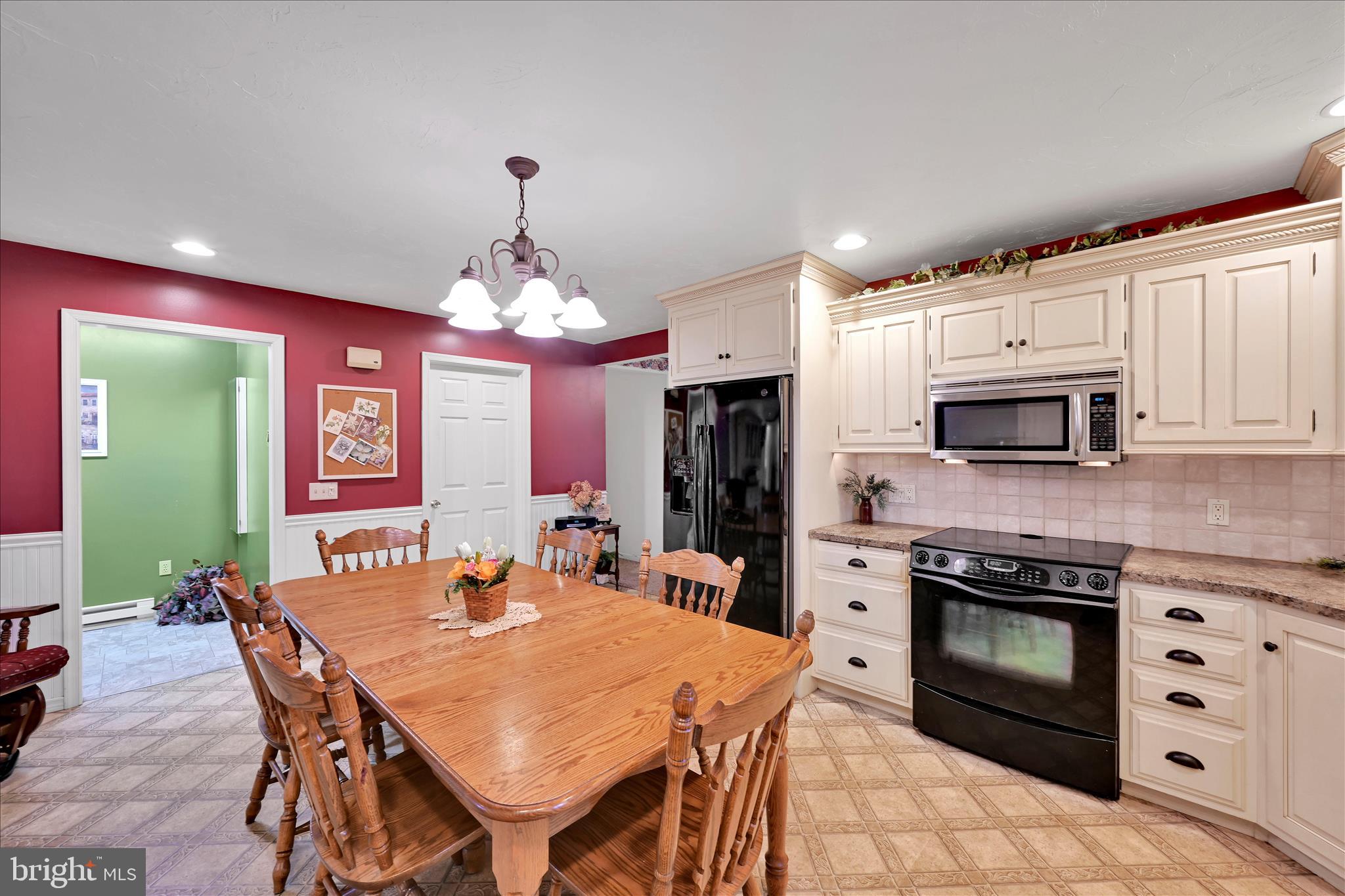 61 West Rosebud Road Myerstown, PA 17067 - Photo 21 of 58 a kitchen with stainless steel appliances kitchen island granite countertop a stove a sink dishwasher a microwave oven with a dining table and chairs