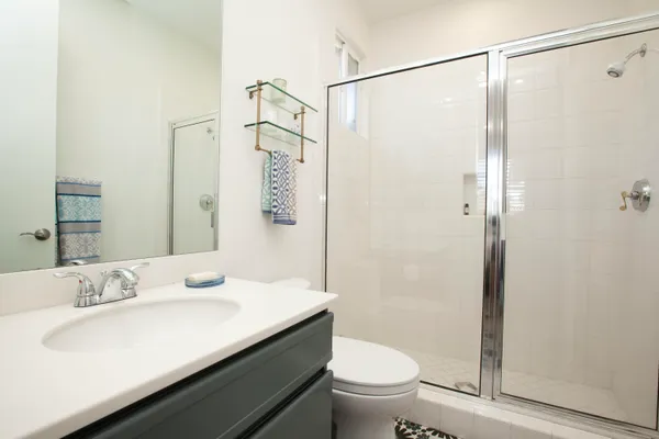 a bathroom with a sink a toilet and shower