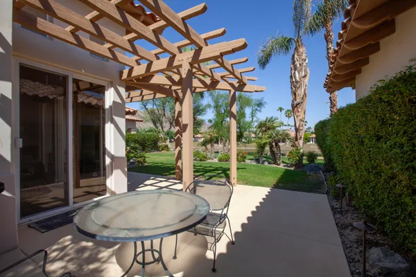 a backyard of a house with fountain table and chairs