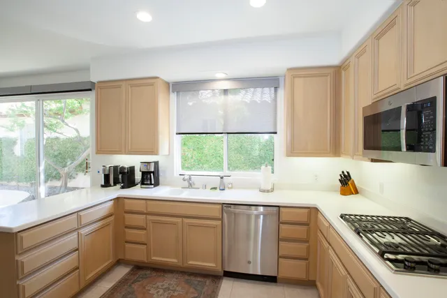 a kitchen with sink a window and cabinets
