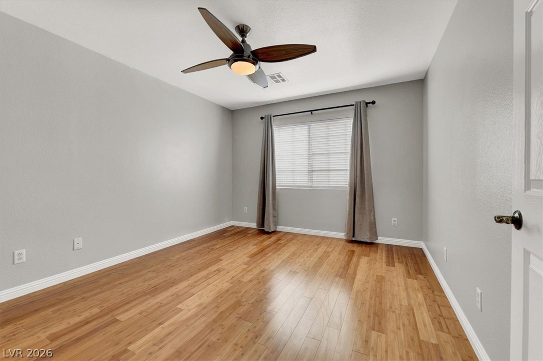 10148 Tree Bark Street Las Vegas, NV 89183 - Photo 21 of 37 Lustrous hardwood flooring stretches throughout this sunlit room, creating a warm and inviting atmosphere.