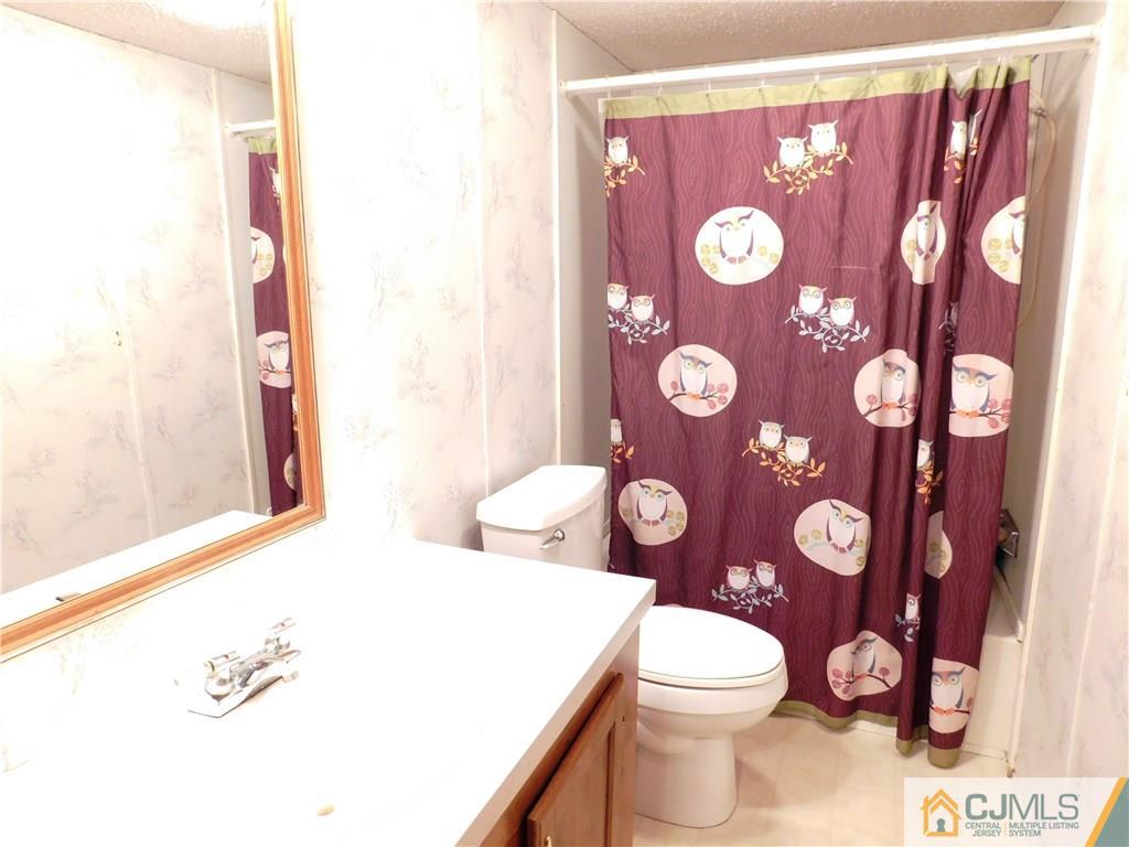 8 Ruffian Way, Unit 8 Howell, NJ 07731 - Photo 11 of 12 a bathroom with a toilet and a shower curtain
