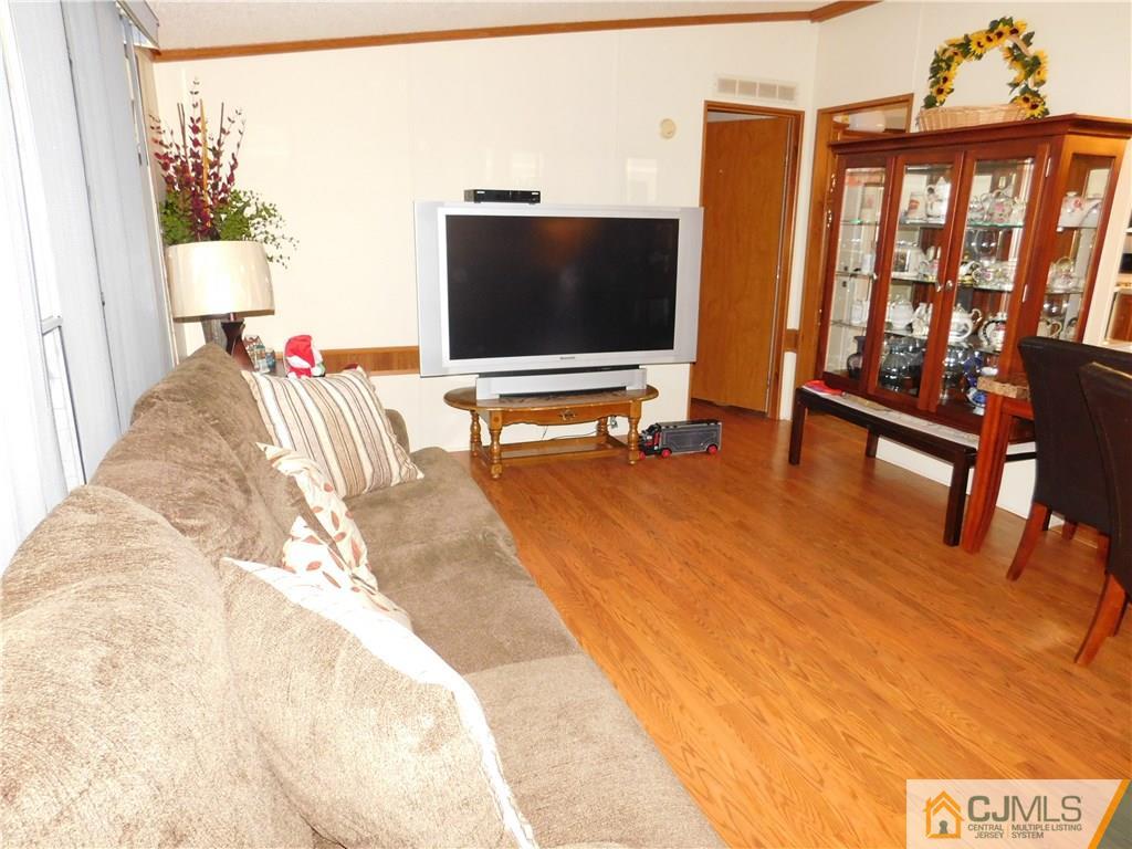 8 Ruffian Way, Unit 8 Howell, NJ 07731 - Photo 4 of 12 a living room with furniture and a flat screen tv