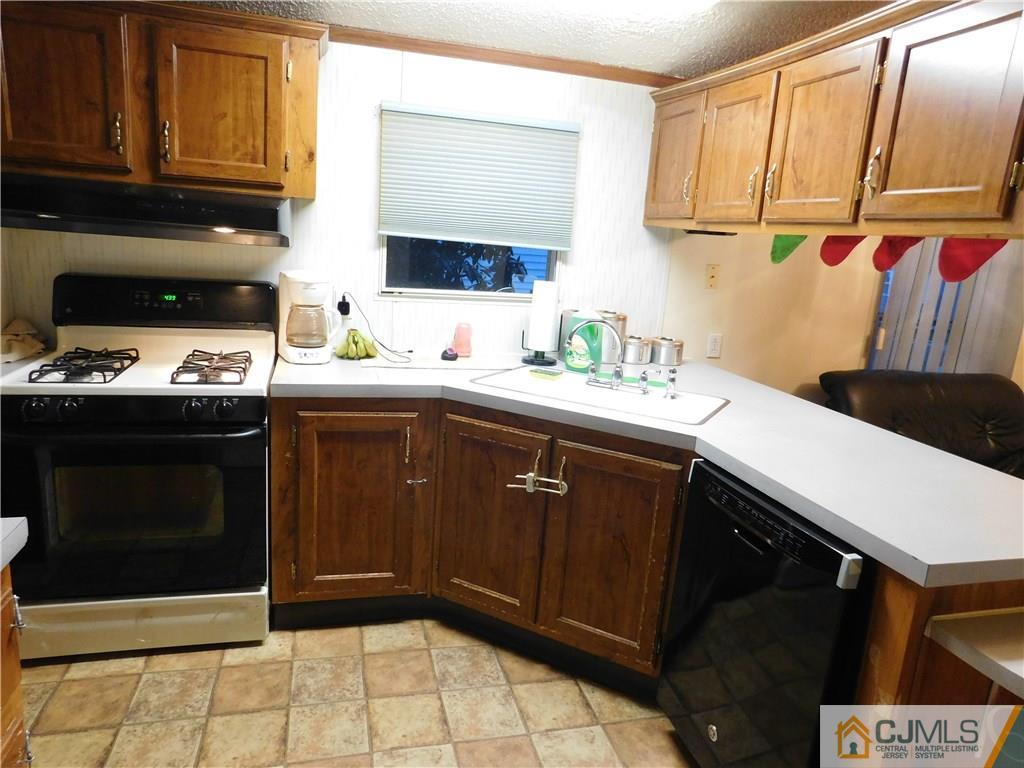 8 Ruffian Way, Unit 8 Howell, NJ 07731 - Photo 7 of 12 a kitchen with stainless steel appliances a sink dishwasher stove and cabinets