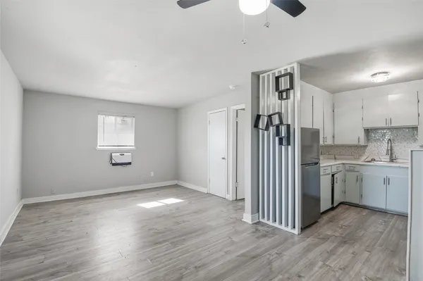 a view of a kitchen with a sink dishwasher cabinets and wooden floor