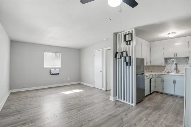 a view of a kitchen with a sink dishwasher cabinets and wooden floor