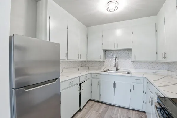a kitchen with a refrigerator sink and cabinets