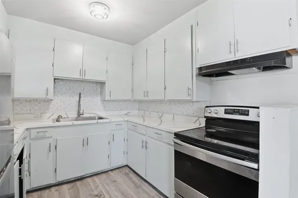 a kitchen with cabinets appliances and a sink