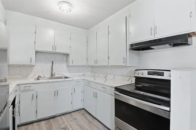 a kitchen with cabinets appliances and a sink