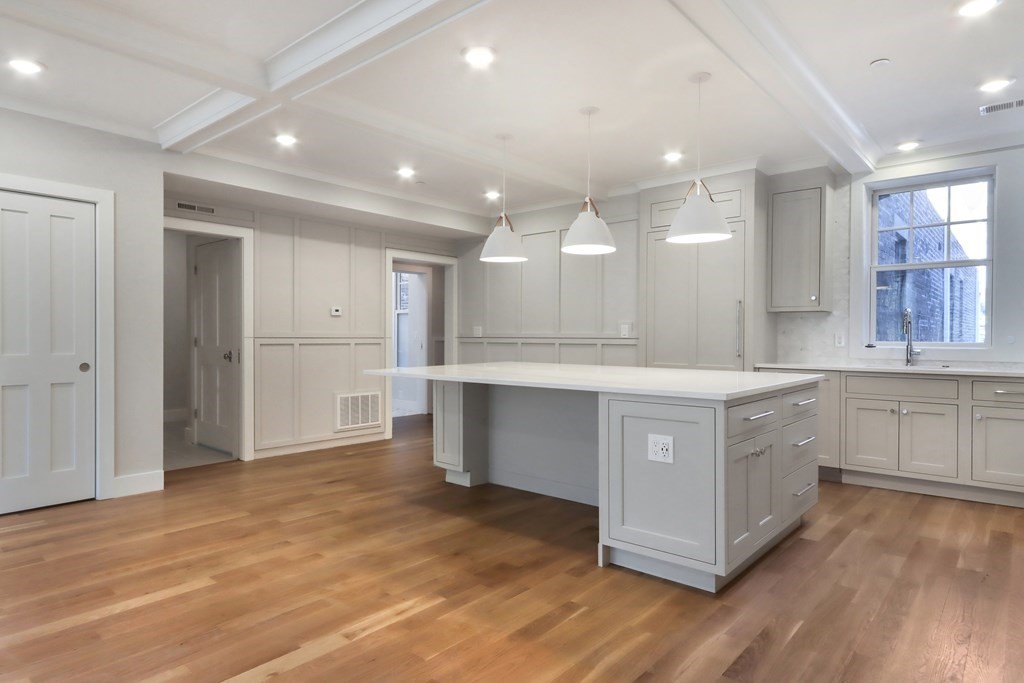 189 Babcock Street, Unit 2 Brookline, MA 02446 - Photo 13 of 39 a large kitchen with a large counter top and stainless steel appliances