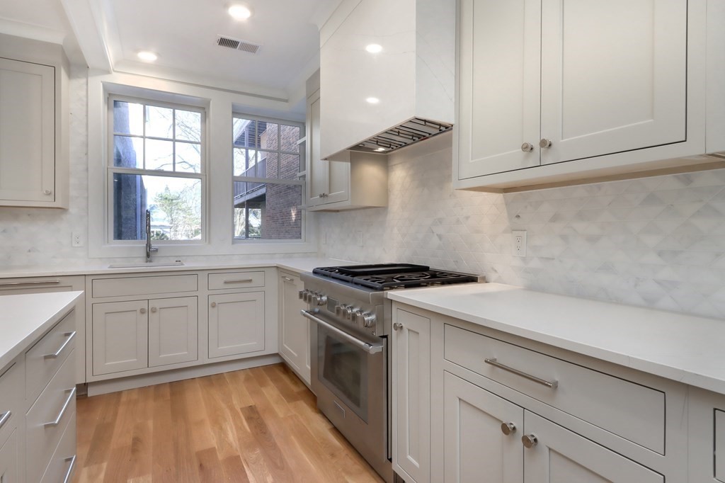189 Babcock Street, Unit 2 Brookline, MA 02446 - Photo 14 of 39 a kitchen with granite countertop cabinets stainless steel appliances and a window