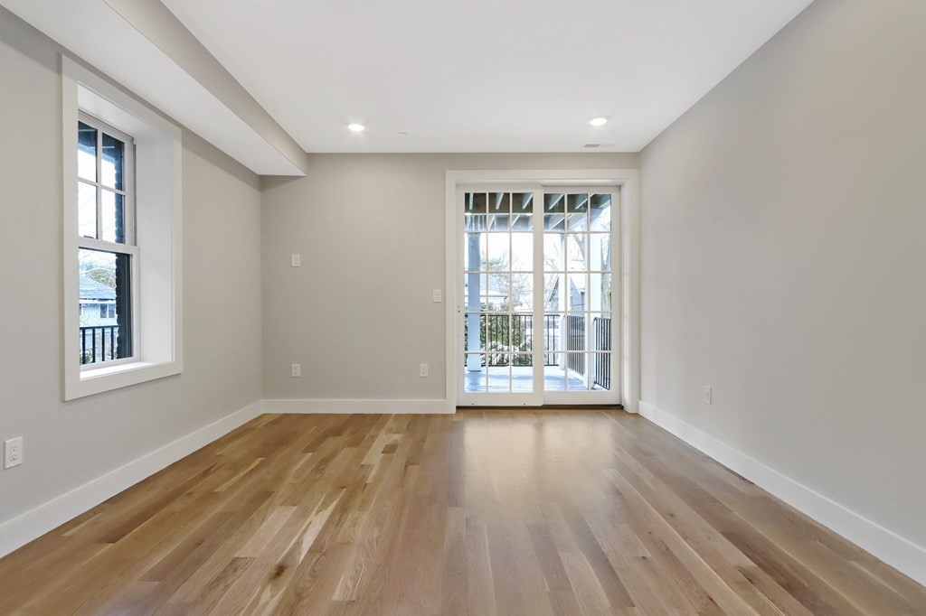 189 Babcock Street, Unit 2 Brookline, MA 02446 - Photo 21 of 39 a view of an empty room with wooden floor and a window