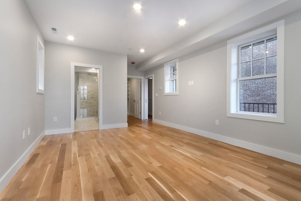 189 Babcock Street, Unit 2 Brookline, MA 02446 - Photo 22 of 39 a view of an empty room with wooden floor and a window