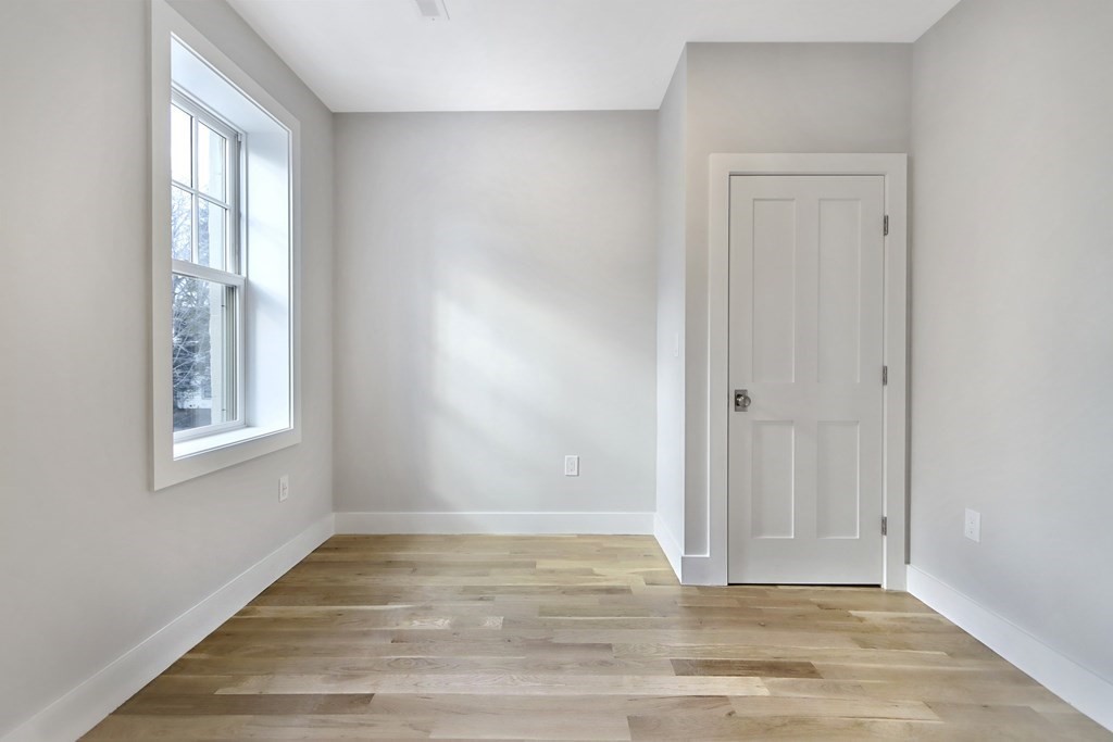 189 Babcock Street, Unit 2 Brookline, MA 02446 - Photo 33 of 39 a view of an empty room with wooden floor and a window