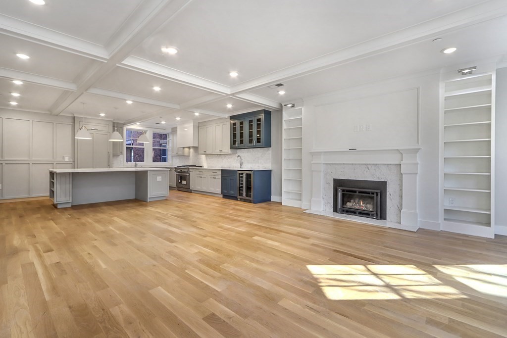 189 Babcock Street, Unit 2 Brookline, MA 02446 - Photo 6 of 39 a view of kitchen and empty room with fireplace