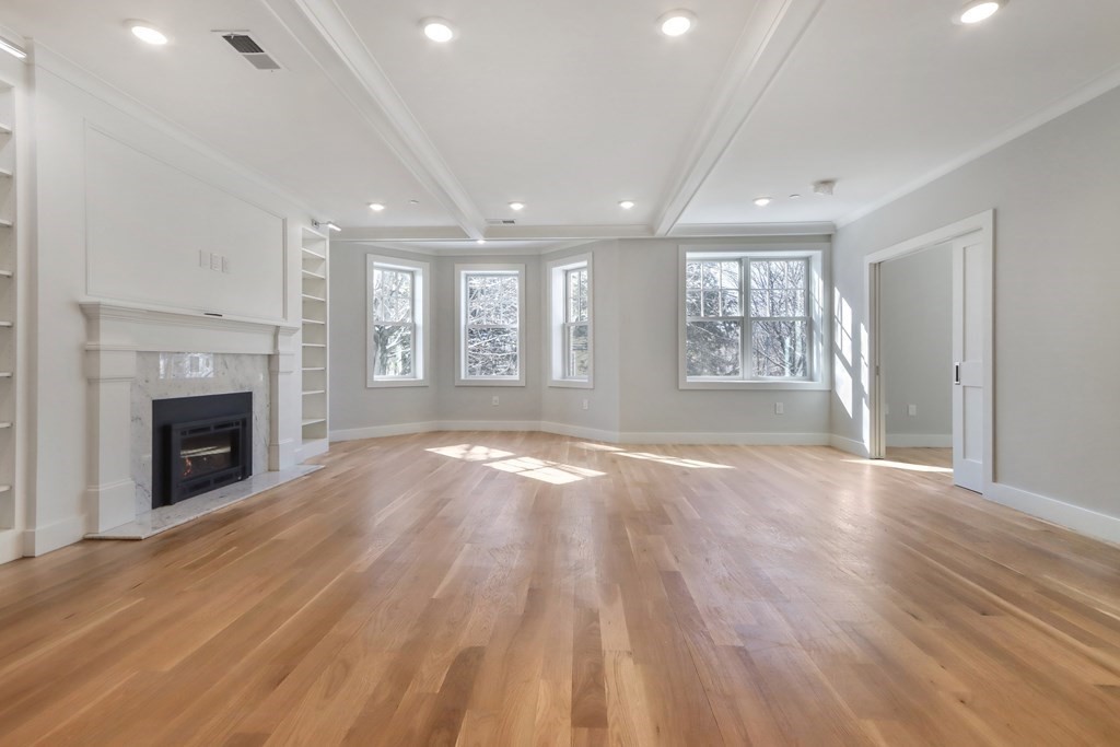 189 Babcock Street, Unit 2 Brookline, MA 02446 - Photo 7 of 39 an empty room with windows and fireplace