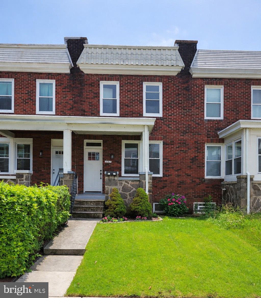 front view of a brick house with a yard
