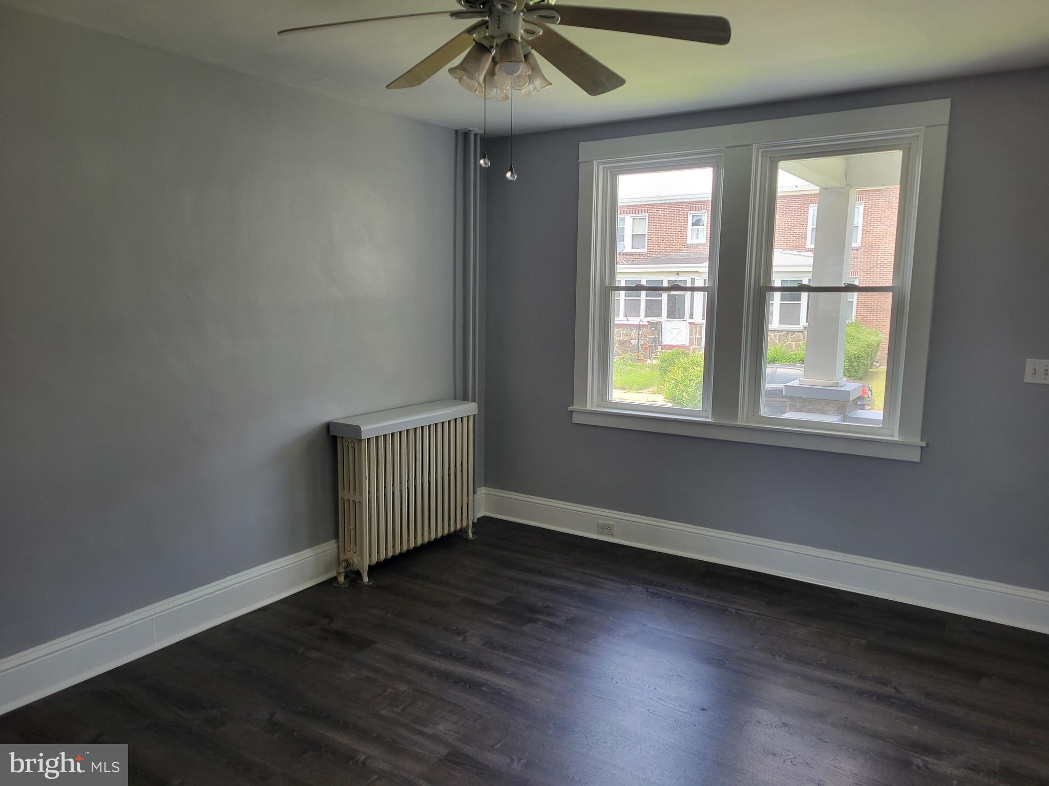 6757 Woodley Road Dundalk, MD 21222 - Photo 12 of 27 an empty room with wooden floor chandelier fan and windows