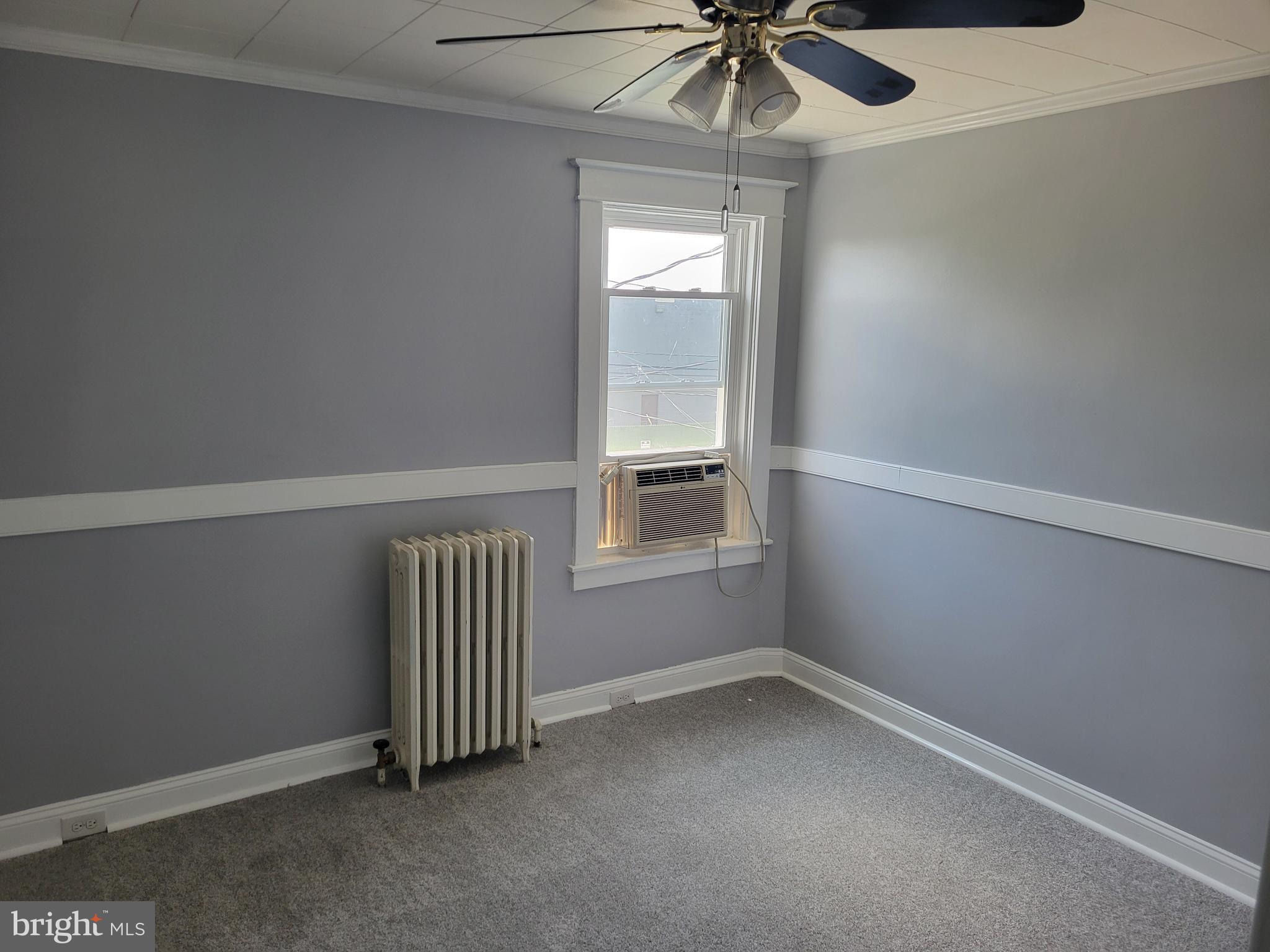 6757 Woodley Road Dundalk, MD 21222 - Photo 13 of 27 an empty room with a window and ceiling fan