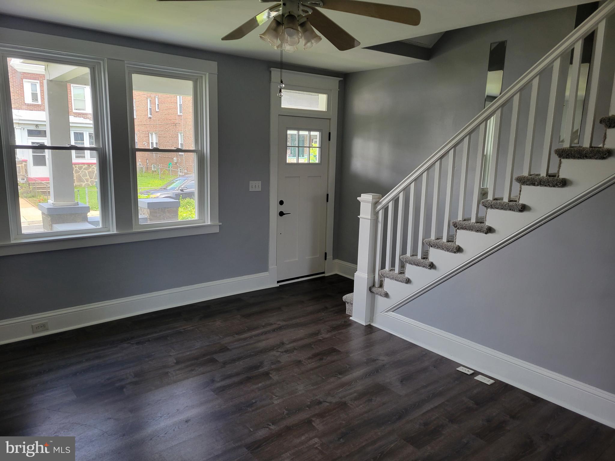 6757 Woodley Road Dundalk, MD 21222 - Photo 7 of 27 a view of an entryway with wooden floor stairs and a chandelier fan